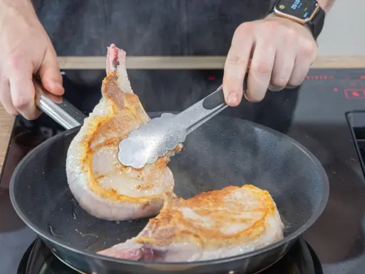 Zwei saftige Koteletts braten in der Pfanne. Perfekt für leckere Kotelett Rezepte.