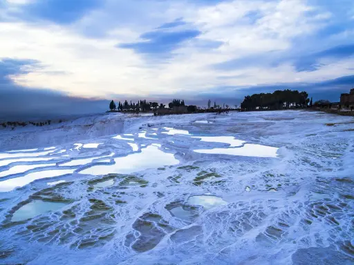 Błękitne niebo nad tarasami Pamukkale. Woda w basenach jest zimna, co może sugerować, czy w Turcji jest zima.