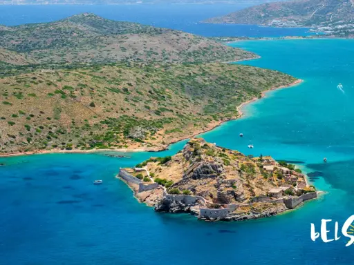 Kreta, lipiec: słoneczna pogoda i turkusowe morze otaczają skalistą wyspę z ruinami fortecy.