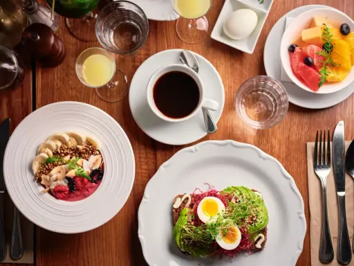 En härlig frukost i Stockholm med en smoothie bowl, avokadotoast, frukt och kaffe.