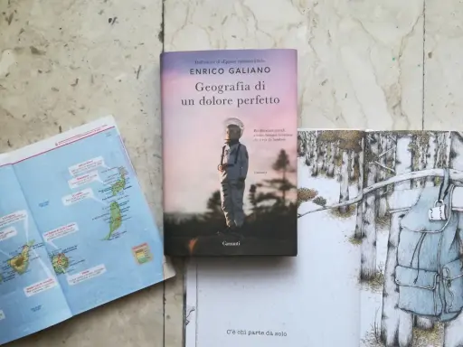Mappa delle Canarie, libro "Geografia di un dolore perfetto" e illustrazione di uno zaino in un bosco innevato.
