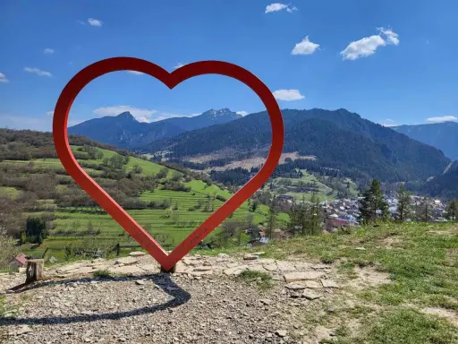 Czerwone serce na tle górskiej panoramy Słowacji. Widok z wieży widokowej na malowniczą dolinę i miasteczko.