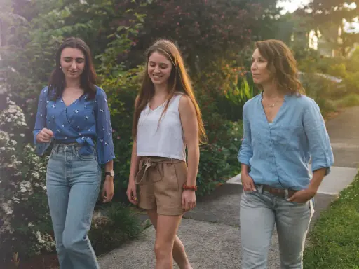 Trois femmes profitent d'une promenade paisible, savourant le moment présent. Une scène de slow tech, où la connexion humaine prime sur le numérique.