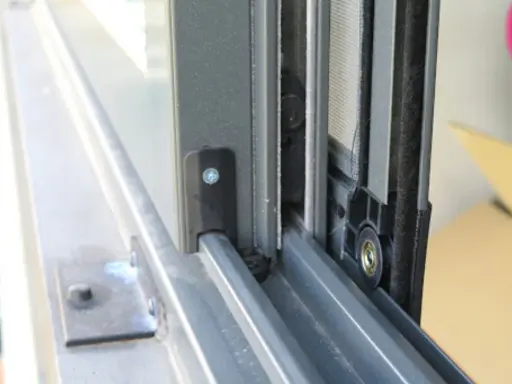 Detalle de cómo hacer una mosquitera corredera: el marco de aluminio y la malla en un riel.