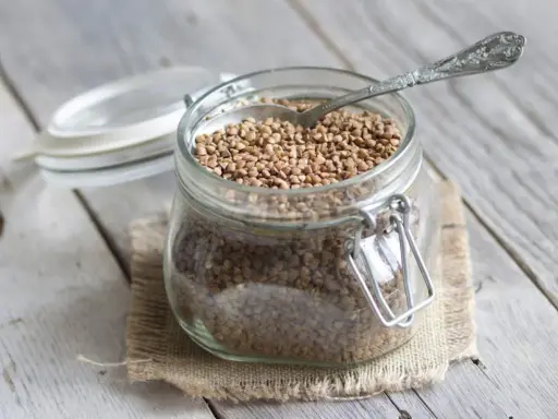 Un bocal en verre rempli de sarrasin, prêt à être cuisiné. C'est quoi le sarrasin ? Une graine nutritive et polyvalente.