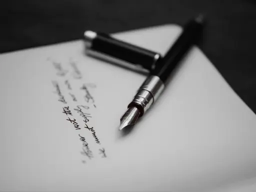 Pióro wieczne na papierze, gdzie widnieje fragment tekstu, być może ostatnia wola lub testament.