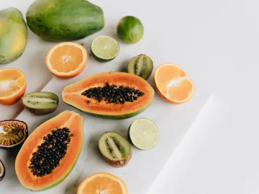 Kolorowe owoce: papaja, kiwi, pomarańcze, limonki i marakuja. Czy owoce tuczą? Te na zdjęciu wyglądają zdrowo i pysznie!