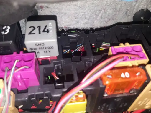 Skrzynka bezpieczników Audi A4 B5 z widocznymi przekaźnikami i kolorowymi bezpiecznikami.
