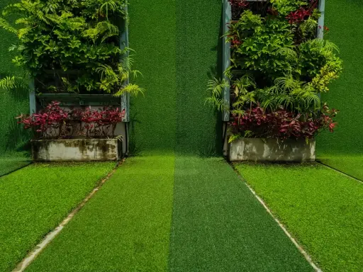 Dos jardines verticales con diferentes tipos de césped y plantas. El camino central muestra dos tonos de césped artificial.