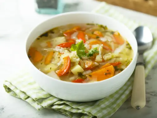 Aromaticzny kapuśniak ze słodkiej kapusty z marchewką i ziemniakami, udekorowany natką pietruszki. Idealny na chłodne dni.