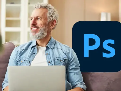 Uśmiechnięty mężczyzna z laptopem i logo Photoshop.