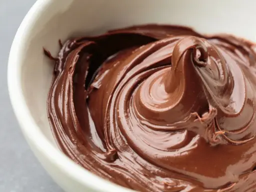 Cremige Schokoladencreme in einer weißen Schüssel. Ein Traum für alle, die Nutella selber machen gesund wollen.