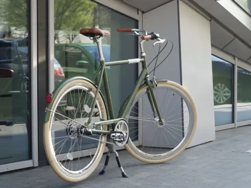Stylowy, zielony rower do miasta z brązowym siodełkiem i uchwytami, gotowy na miejskie przygody.