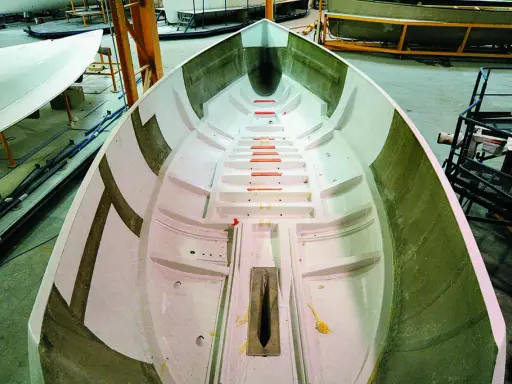 Intérieur d'une coque de bateau en construction, prêt pour le talonnage bateau. Lignes épurées et structure visible.