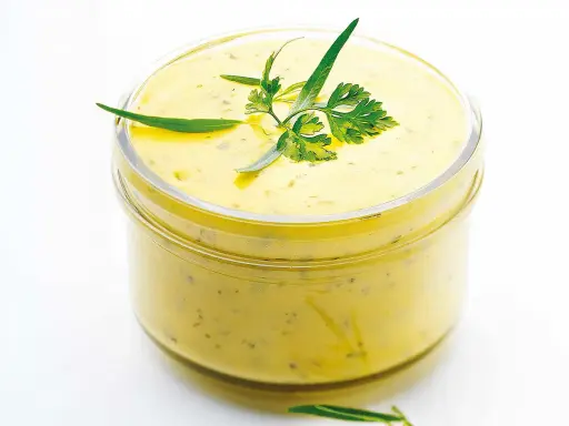 Sauce béarnaise onctueuse dans un bocal, garnie d'herbes fraîches. Parfaite pour accompagner vos plats, cette recette est un délice.