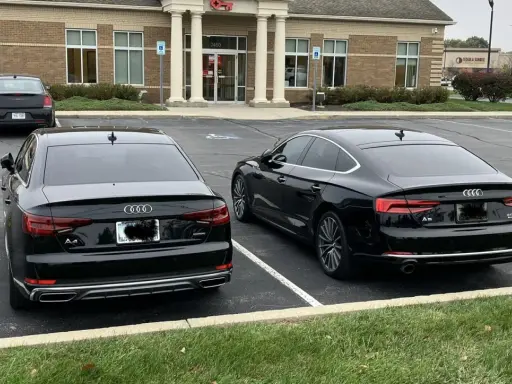 Dos Audis negros, un A4 y un A5, aparcados uno al lado del otro.
