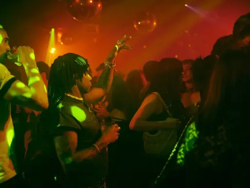 Persone che ballano in un locale notturno, luci stroboscopiche e musica alta: il vero clubbing significato.