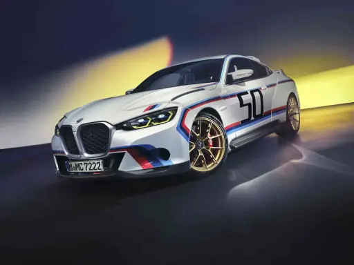 Sportlicher BMW 3.0 CSL in Weiß mit M-Streifen und der Startnummer 50 auf goldenen Felgen.
