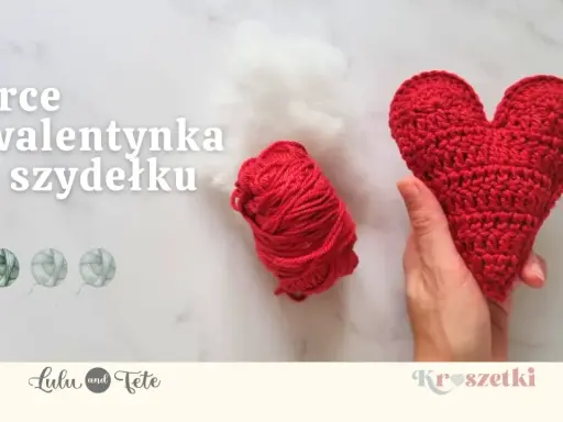 Czerwone serce na szydełku, gotowe na walentynki. Obok kłębek czerwonej włóczki i białe wypełnienie.
