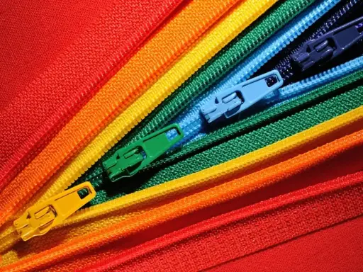 Kolorowe zamki błyskawiczne ułożone w wachlarz. Dowiedz się, jak wszyć zamek z zakładką, tworząc tę tęczową mozaikę.