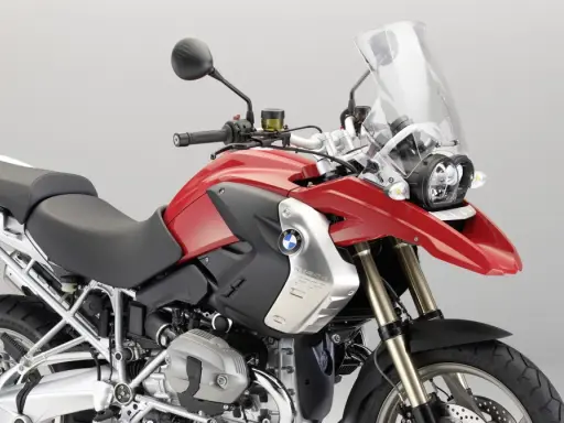 Czerwony motocykl BMW R1200GS z czarnym siedzeniem i dużą szybą.