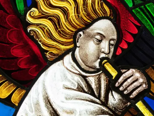 Un ange soufflant dans une trompette, une œuvre d'art vitraux aux couleurs vives.