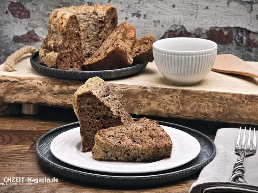 Saftiger **Diabetiker Kuchen** auf rustikalem Holzbrett, serviert auf Tellern mit Gabel.
