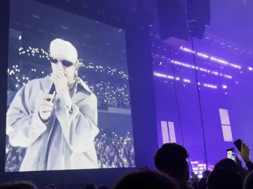 Sobel na ekranie, tłum z telefonami tworzy fiołkowe pole świateł. Koncert w fioletowej poświacie.