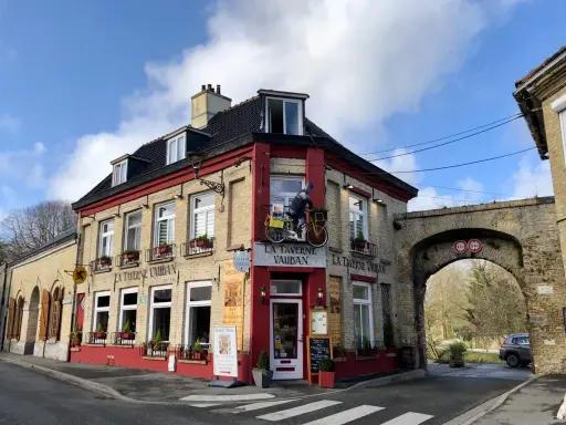 Façade de la Taverne Vauban à Bergues, avec une enseigne et une décoration de cycliste.