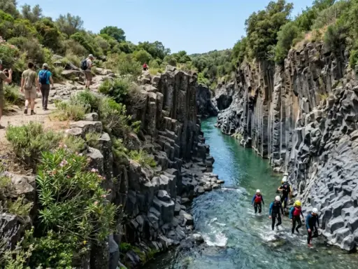 Escursionisti ammirano le spettacolari **cascate gole dell'Alcantara**, mentre un gruppo fa canyoning nel fiume.