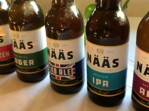 Flera flaskor öl från Nääs bryggeri står uppradade. En flaska med etiketten "Eko Ale" syns tydligt.