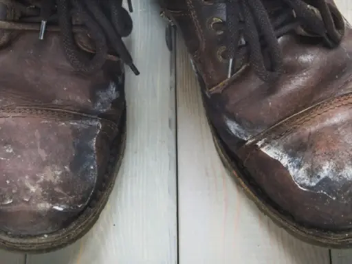 Zimowe buty skórzane pokryte białym nalotem po soli. Dowiedz się, jak usunąć sól z butów skórzanych, by przywrócić im dawny blask.