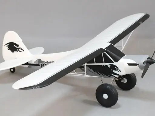 Modellflugzeug Piper PA-18 mit Adler-Design, bereit zum Abheben.