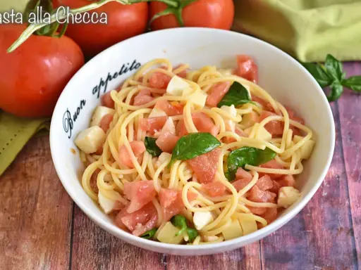 Spaghetti freschi con pomodorini, mozzarella e basilico, un piatto estivo perfetto: pasta alla checca.
