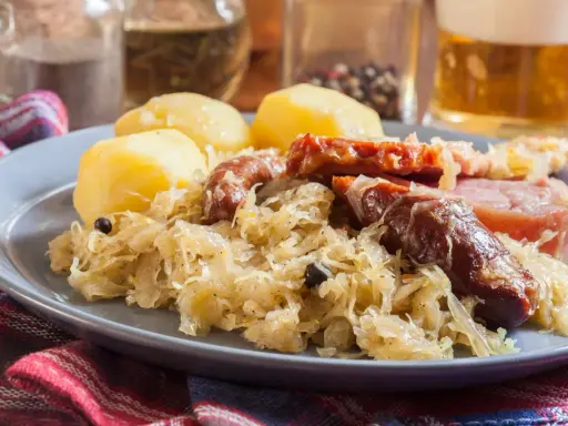 Assiette de choucroute garnie avec pommes de terre, saucisses et lard. Un plat typique de restaurant.