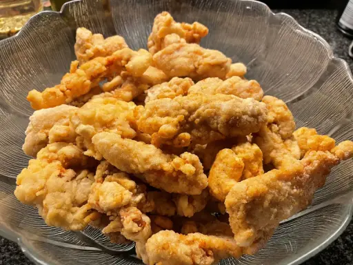 En skål med krispigt, gyllene korean fried chicken. Perfekt för en festlig kväll!