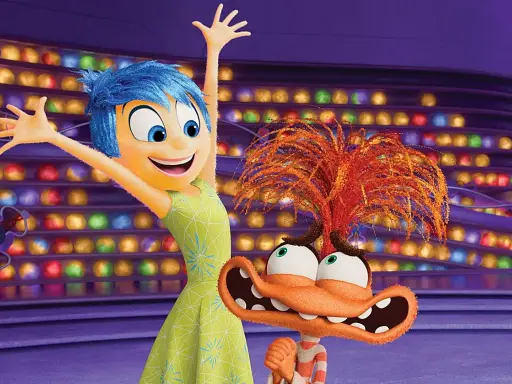 Alegría, del reves 2, salta feliz junto a un personaje naranja con pelo de fuego y ojos saltones, en un escenario de luces de colores.
