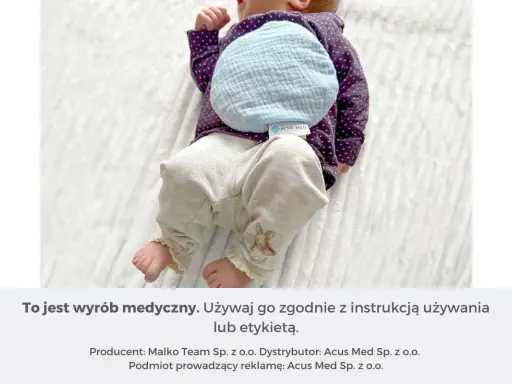 Niemowlę z termoforem z pestek wiśni na brzuszku. Dowiedz się, jak zagrzać taki termofor, by przyniósł ulgę.