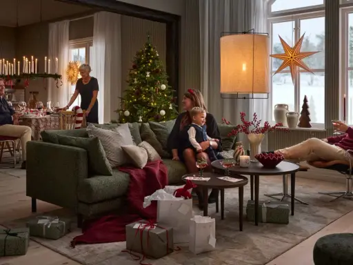 En familj njuter av en mysig julkväll med en sprakande brasa med lugn julmusik. Presenter och julgran bidrar till stämningen.
