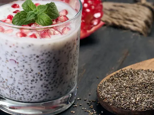 Chia-Samen-Pudding mit Granatapfel und Minze. Bei übermäßigem Verzehr können Chia-Samen Nebenwirkungen haben, auch für die Leber.