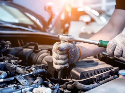Mecánico revisa el motor de un coche. Aprende como saber si un motor esta quemado observando los componentes.