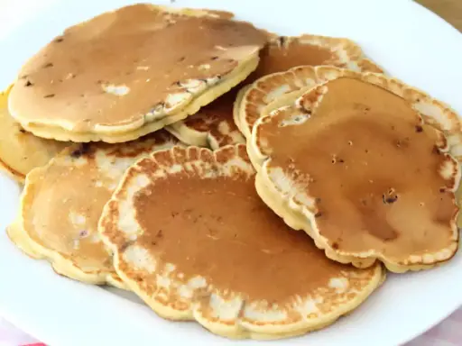 Pile de pancakes dorés aux pépites de chocolat, parfaits pour une recette gourmande.