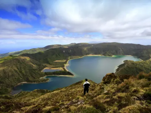 Ein Mann blickt auf eine atemberaubende Kraterlandschaft mit mehreren Seen. Die Frage, ob Madeira zu den Azoren gehört, wird hier durch die Schönheit der Natur beantwortet.