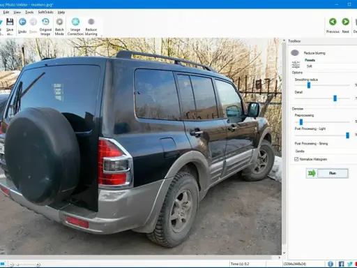 Software per correggere foto mosse. L'immagine mostra un SUV nero con una ruota di scorta sul retro, pronto per essere elaborato.
