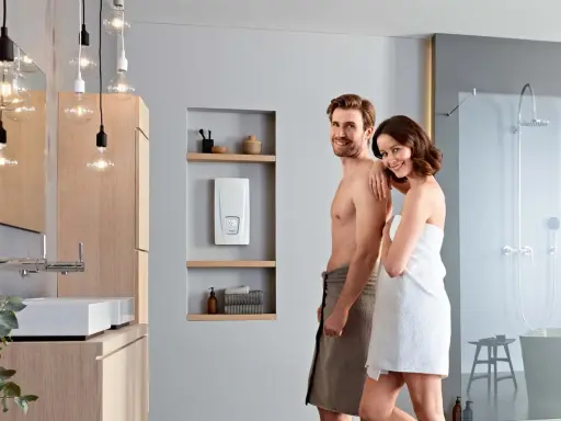 Glückliches Paar im Bad, neben dem besten Durchlauferhitzer. Modernes Bad mit Dusche und Waschbecken.