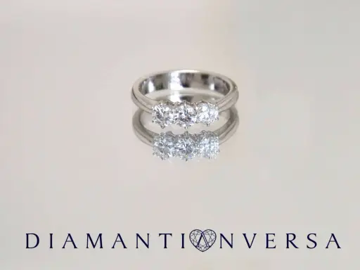 Un anello prezioso con tre diamanti scintillanti, riflesso su una superficie lucida.