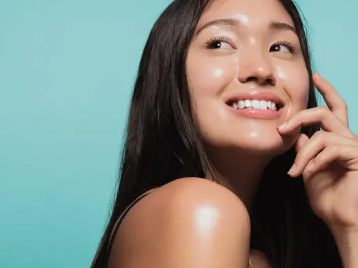 Donna sorridente con pelle luminosa e idratata, un esempio di come idratare la pelle senza creme.