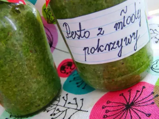 Dwa słoiki z zielonym pesto z pokrzywy, jedno z etykietą "Pesto z młodej pokrzywy".
