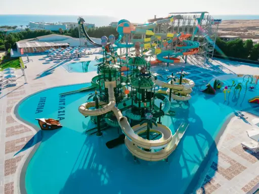 Kolorowy aquapark Fantazia Resort Marsa Alam z licznymi zjeżdżalniami i basenami, w tym z motywem statku pirackiego.