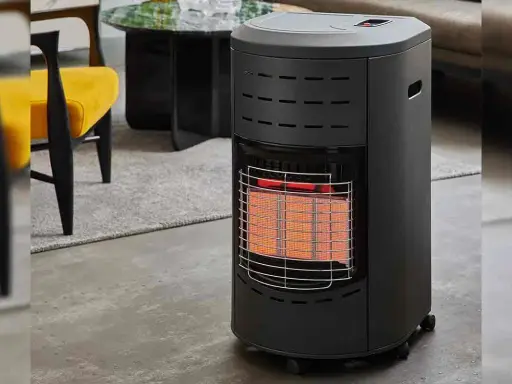 Chauffage d'appoint gaz danger : appareil noir avec grille métallique devant des éléments chauffants rouges, dans un salon moderne.